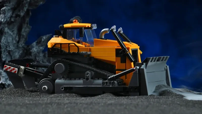 Nahaufnahme des Räumschilds und der Ketten des LEGO Gelben Bulldozers (60466), inszeniert mit Fels- und Nebelrequisiten