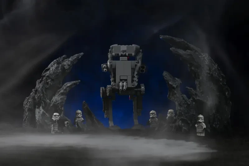 Ein LEGO AT-ST-Walker frontal fotografiert zwischen zwei zerklüfteten Felsformationen, mit weichem blau beleuchtetem Nebel