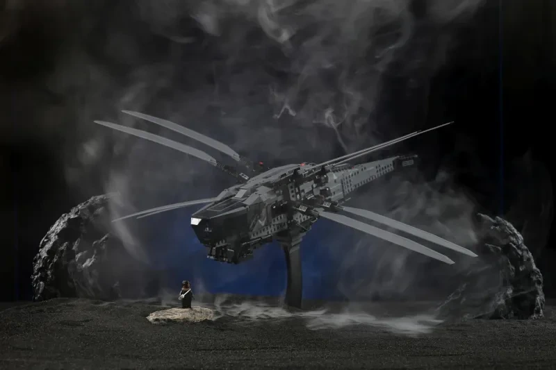 Ein futuristisches LEGO-Raumschiffmodell über schwarzem, vulkanischem Terrain, eingehüllt in dichten Nebel der PMI SmokeNINJA